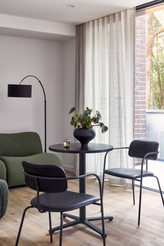 a living room with a table and chairs and a large window