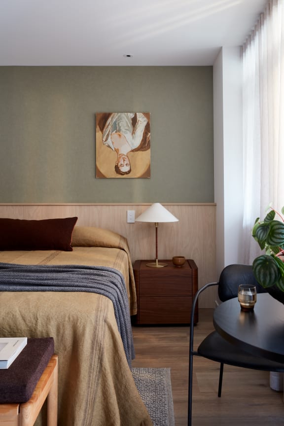 a hotel room with a bed and a painting on the wall