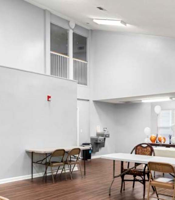 an empty living room with a table and chairs