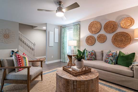 a living room with couches and chairs and baskets on the wall