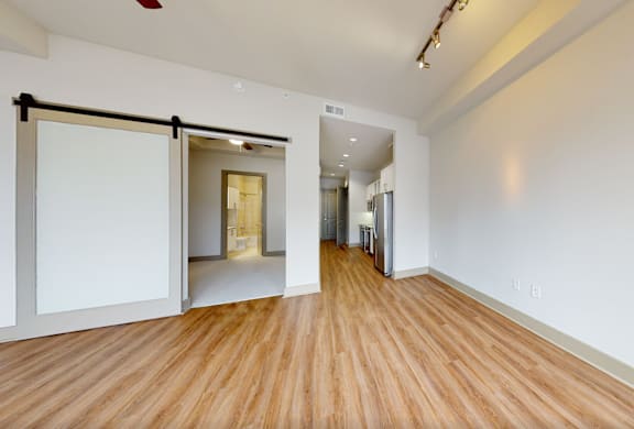 A room with a sliding door and wooden flooring.