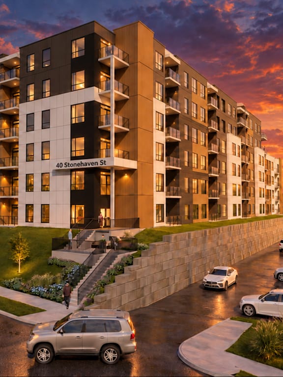 A modern apartment building with cars parked in front.