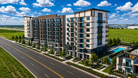 A modern apartment building with a pool and a road in front.
