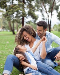 family of three in park hugging