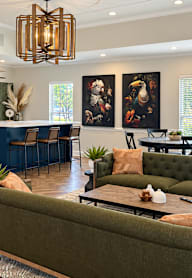 A living room with a dark green couch and a wooden coffee table.
