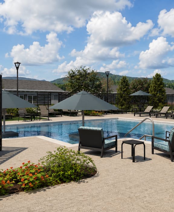 Two black chairs are placed on a patio in front of a pool.
