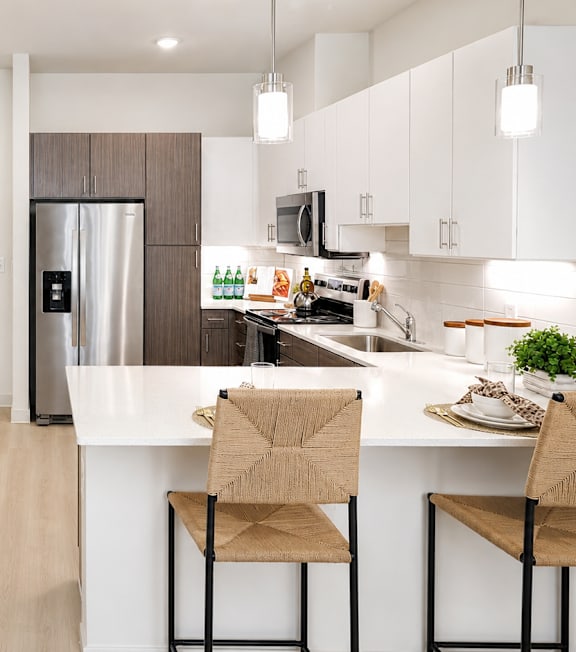 A kitchen with a white counter and a refrigerator.