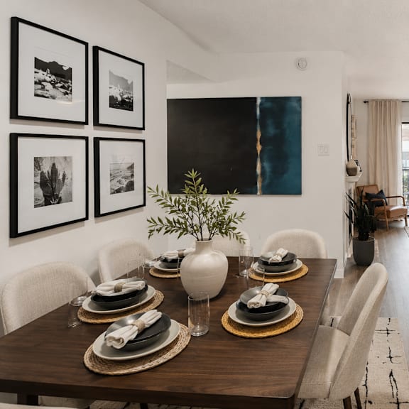 A dining room with a table set for a meal.