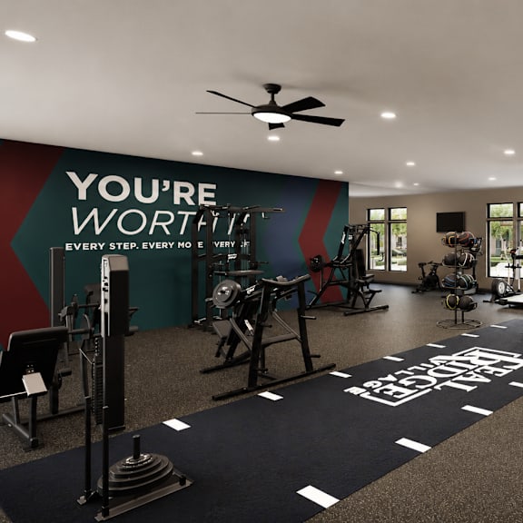 A gym with a variety of equipment and a motivational message on the wall.