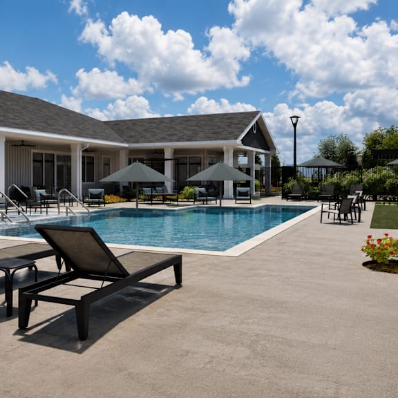 A pool area with a building and loungers.