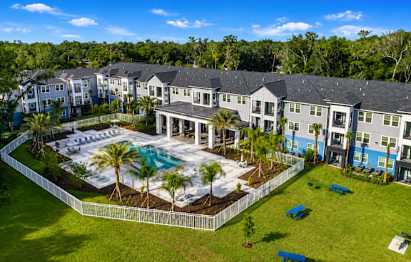 A large white building with a pool and playground in front.