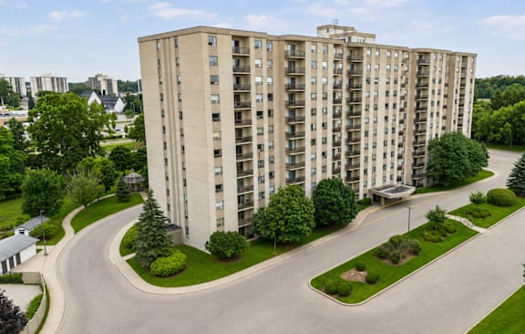 A tall residential building with a green lawn in front.