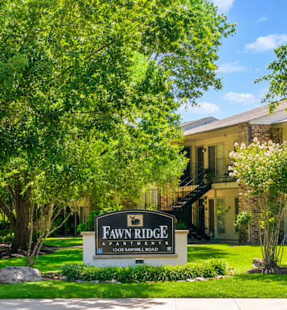 A sign that says "Fawne Ridge" in front of a house.
