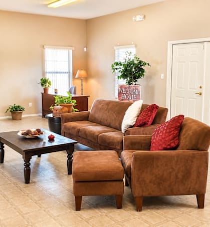 A living room with a brown couch and a coffee table.
