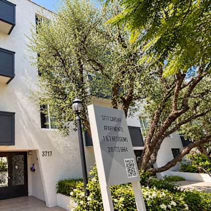 A modern building with a sign for "STUDIO CLOSED" and a phone number.