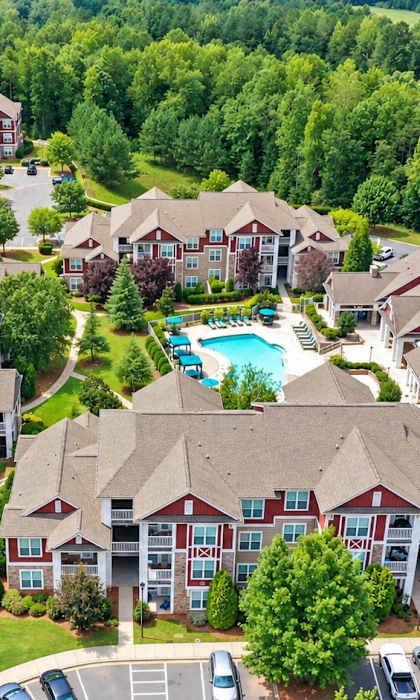 A bird's eye view of a residential area with houses and a swimming pool.