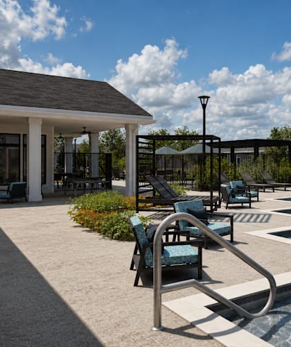 A poolside area with chairs and an umbrella.