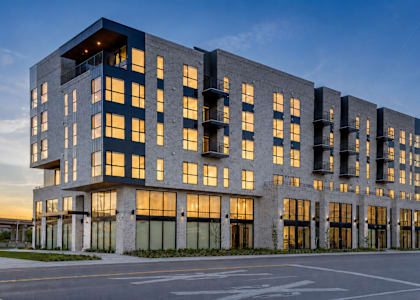 A modern multi-story building with large windows and a flat roof.