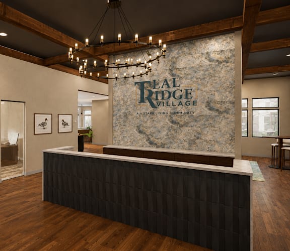 A reception area for Real Ridge Village Community with a stone backdrop and a black reception desk.