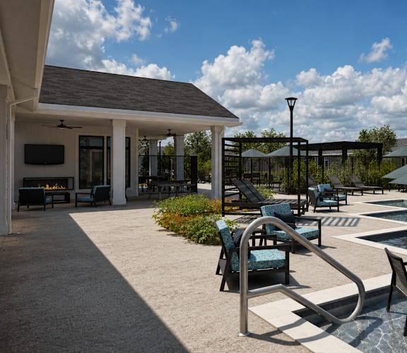 A poolside area with chairs and an umbrella.