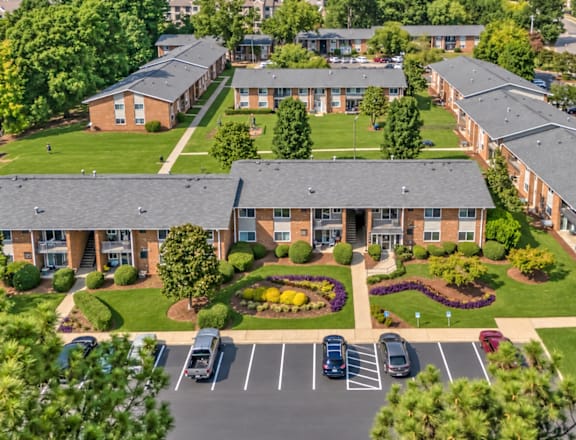 A large apartment complex with a parking lot in front.