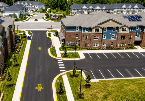 A road with a yellow sign that says "STOP HERE ON RED" in front of apartment buildings.