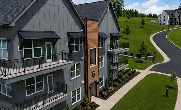 A modern apartment complex with a curved road in front.