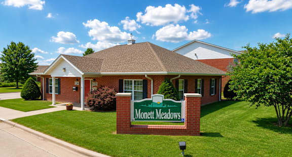 The image shows a building with a sign that reads "Monett Meadows.".
