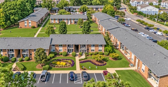 A large apartment complex with a parking lot in front.