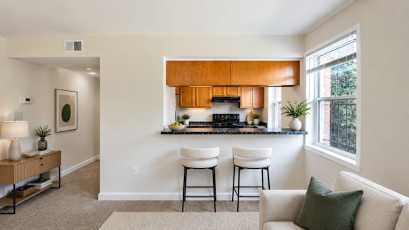 A kitchen with a bar stool and a couch.