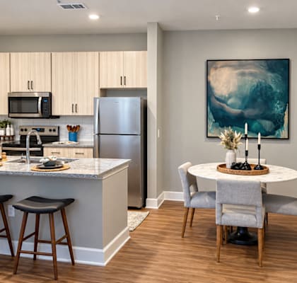 A kitchen with a bar and a dining table.