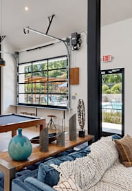 A living room with a pool table and a couch.