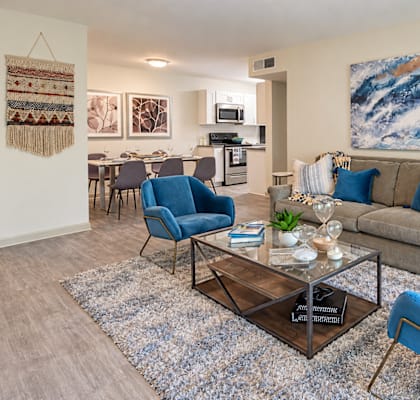 A living room with a blue chair and a grey couch.
