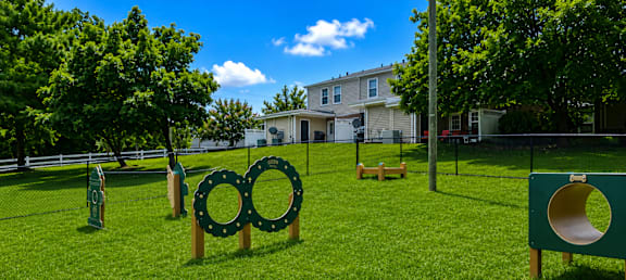 A playground with a slide and a green sign with a yellow circle on it.