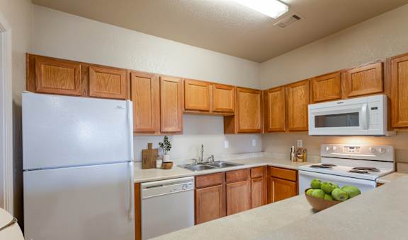 a kitchen with white appliances and wooden cabinets