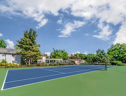 a tennis court with trees and a house in the background at Quail Ridge, Plainsboro Township, NJ, 08536