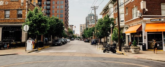 a city street with buildings and a motorcycle parked on the sidewalk