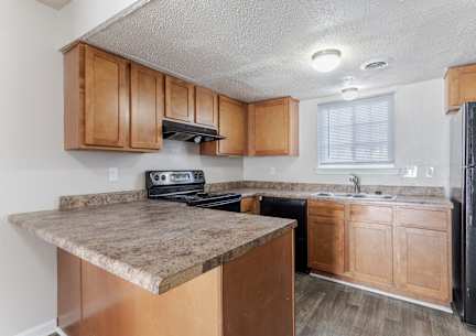 a kitchen with wooden cabinets and a black refrigerator