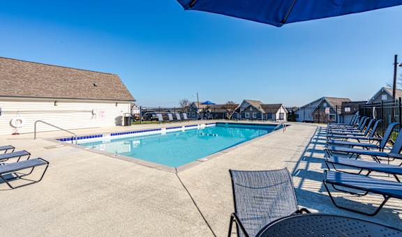 Affordable Antioch, TN Apartments – Hickory Lake – A pool surrounded by chairs and umbrellas.