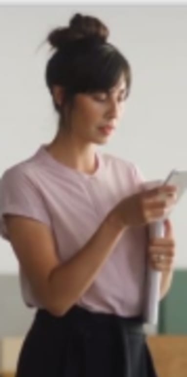 a woman standing in a room looking at her cell phone