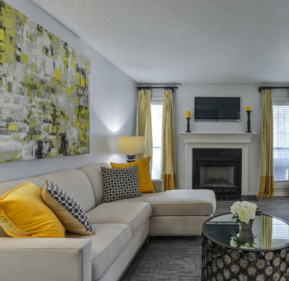 a living room with a fireplace and a couch and a table at SoCO Apartments at Vinings, Smyrna, 30080 at SoCO Apartments at Vinings, Smyrna, 30080 at SoCO Apartments at Vinings, Smyrna, 30080 at SoCO Ap