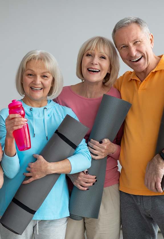 a group of people holding yoga mats