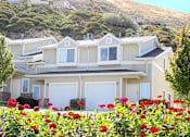 Thumbnail 2 of 26 - Residential building with vibrant red flower garden at Liberty Hill Apartments, Draper