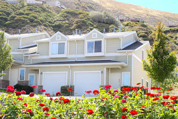 Residential building with vibrant red flower garden at Liberty Hill Apartments, Draper
