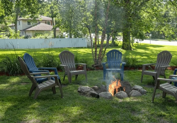 a group of adirondack chairs around a fire pit