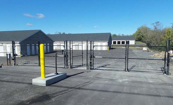 a fenced in area with a chain link fence and a building in the background