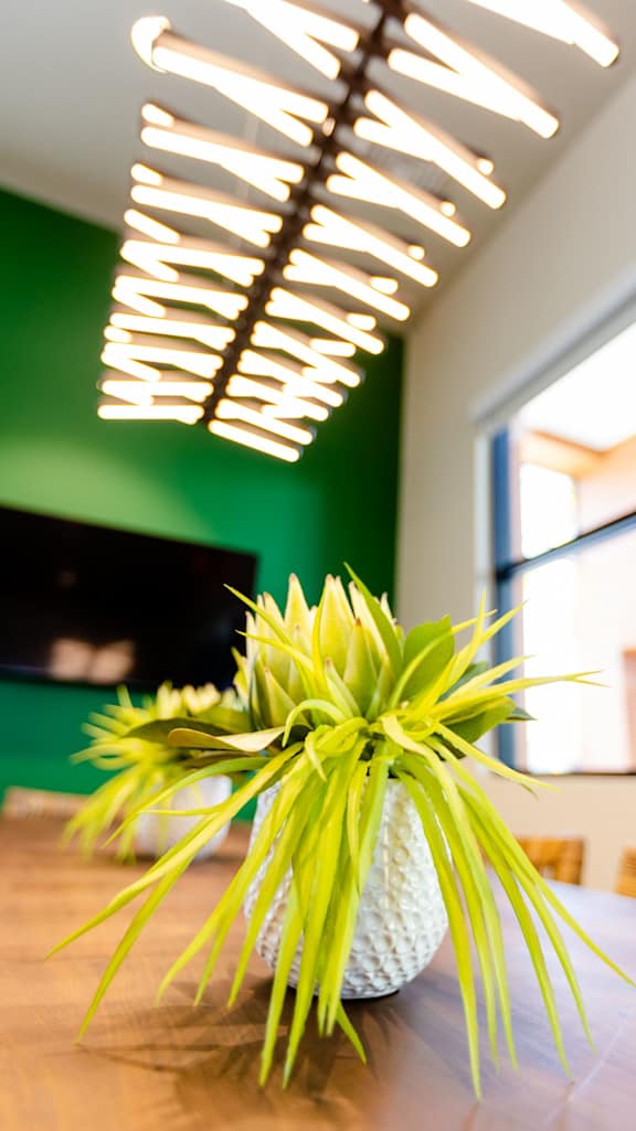A dining room with a white table and green chairs.