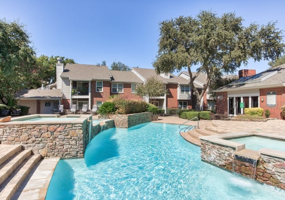a large swimming pool with a house in the background