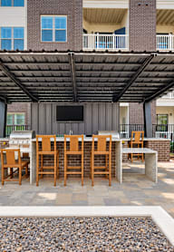 A patio with a table and chairs under a roof.