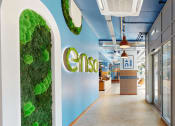Thumbnail 1 of 8 - a green wall with the logo on it in a lobby